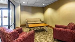 Une pièce comprenant un canapé, deux fauteuils, une table basse et un tapis à motifs.