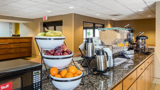Un espace buffet avec des corbeilles de fruits, des machines à café et un four à micro-ondes.