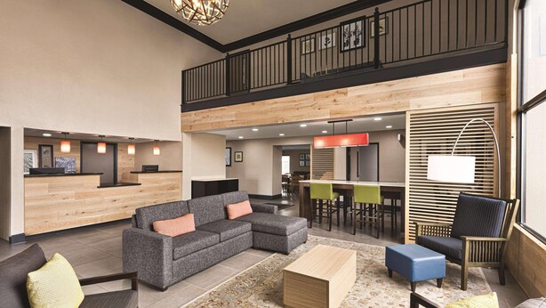 A spacious lobby with a reception desk, seating area, and a staircase leading to an upper level.