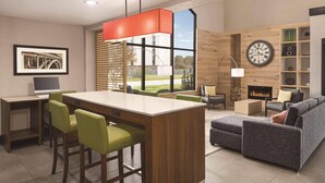 A modern living room with a dining area, a fireplace, and a large window.
