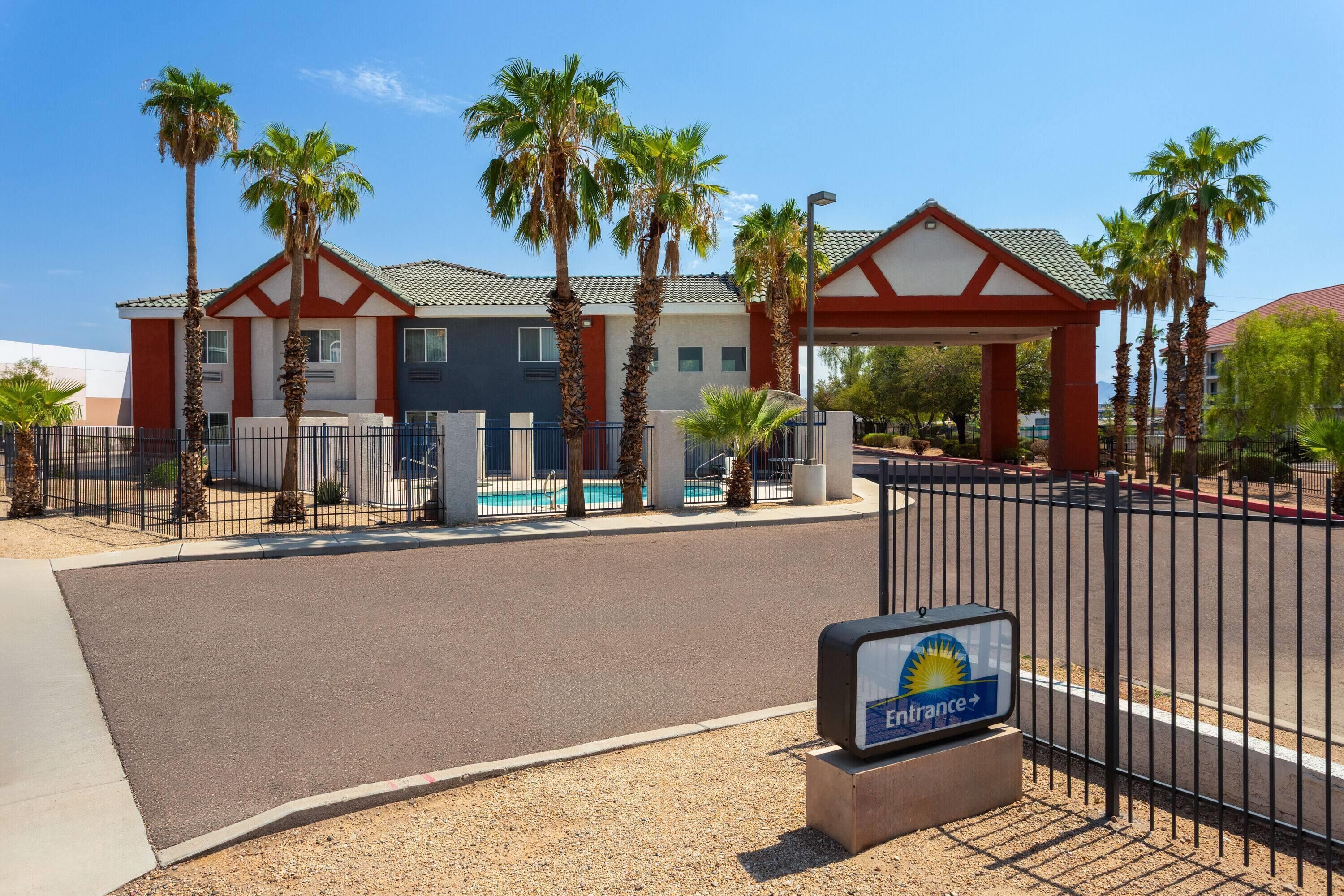 A hotel with a swimming pool, palm trees, and a sign indicating it's an Enfrance hotel.
