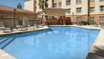 Relax by the pool surrounded by comfortable lounge chairs and umbrellas.