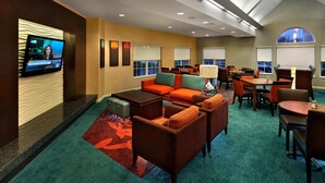 A hotel lobby with a television, seating area, and large windows. - Residence Inn Marriott Danbury (Danbury)