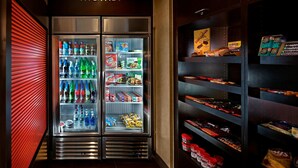 A refrigerated display case with various beverages and snacks, and adjacent shelves stocked with packaged goods. - Residence Inn Marriott Danbury (Danbury)
