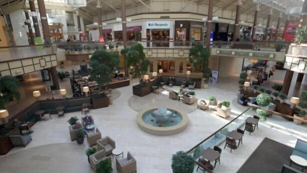 A spacious indoor area with multiple levels, seating areas, and a central fountain. - Maron Hotel And Suites (Danbury)
