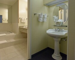 Un baño con una bañera, un lavabo y un espejo.