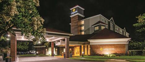 A hotel with a prominent 'La Quinta' sign, a covered entrance, and a well-lit driveway.