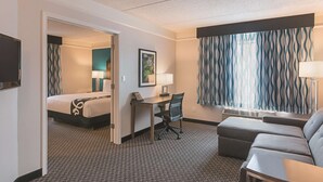 Une chambre d’h ôtel avec un lit, un bureau, une chaise et un canapé.