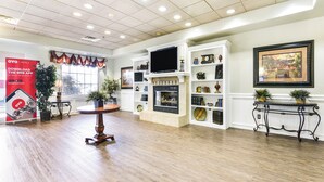 A spacious living room with a fireplace, a television, and a bookshelf.