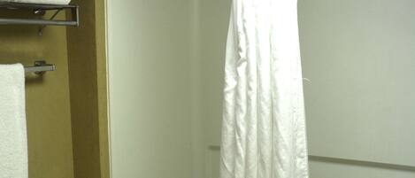 A bathroom with a toilet, a bathtub, and a shower curtain.