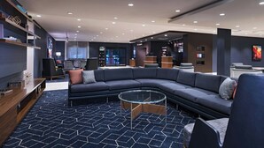 Una sala de estar moderna con un sofá modular, una mesa de centro de vidrio y una alfombra estampada.