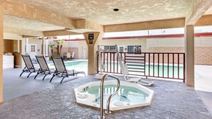 An indoor swimming pool area with a hot tub, lounge chairs, and a view of the outside. - Best Western China Lake Inn (Ridgecrest)