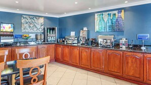 A hotel lobby with a long reception desk, wooden cabinets, a coffee station, and artwork on the walls. - Best Western China Lake Inn (Ridgecrest)