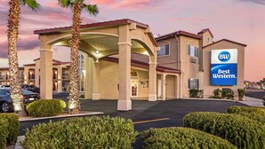 A Best Western hotel with a covered entrance, palm trees, and a parking lot. - Best Western China Lake Inn (Ridgecrest)