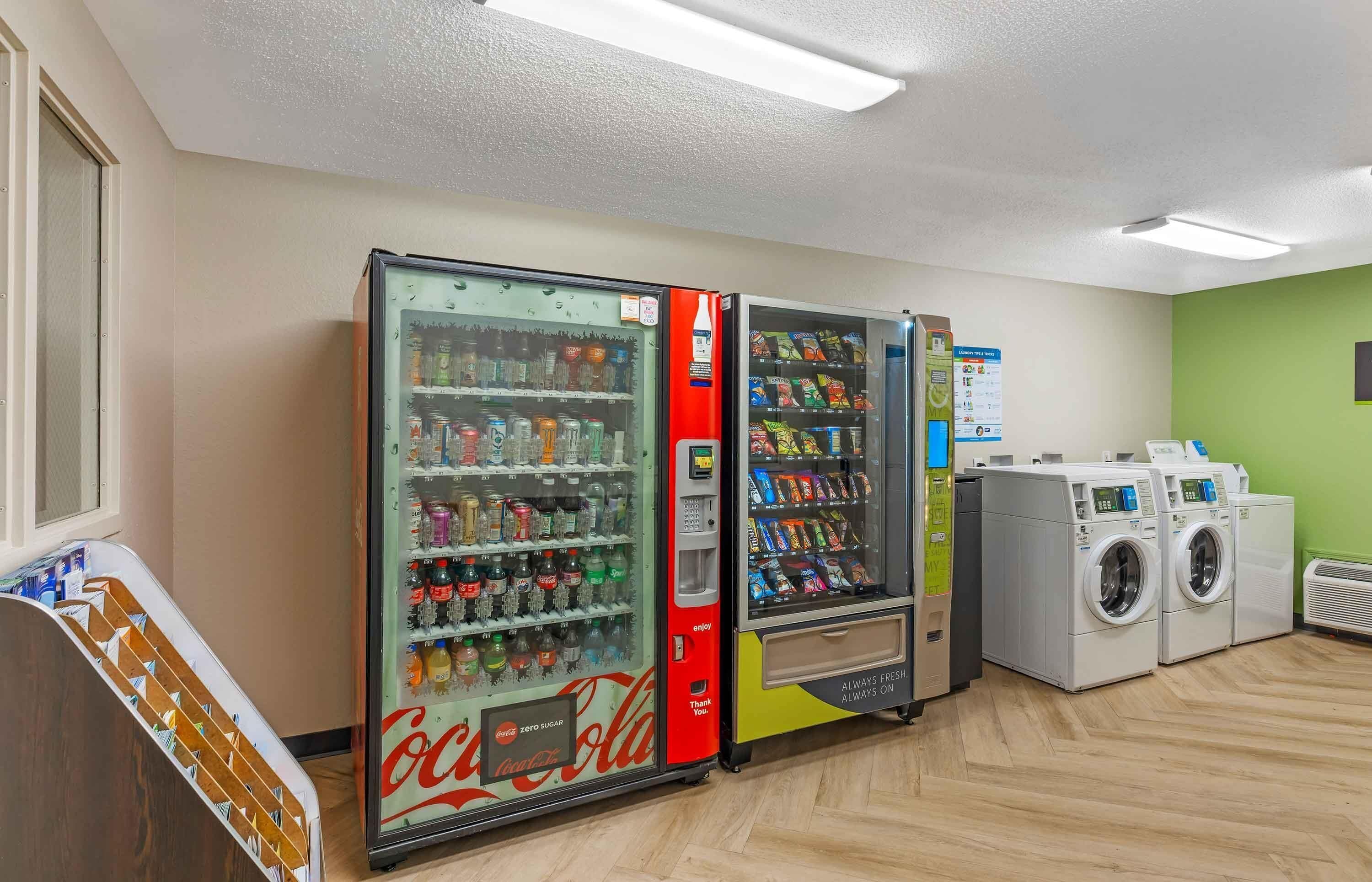 A laundromat with vending machines, a Coca-Cola cooler, and a washing machine.