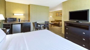 A hotel room with a bed, a desk with a computer, a television, a microwave, and a refrigerator. - Country Inn & Suites by Radisson, Benton Harbor-St. Joseph, MI (Benton Harbor)