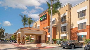 A Stay America hotel with a covered entrance, palm trees, and a parking lot. - Extended Stay America Suites Los Angeles Torrance Del Amo Ci (Torrance)