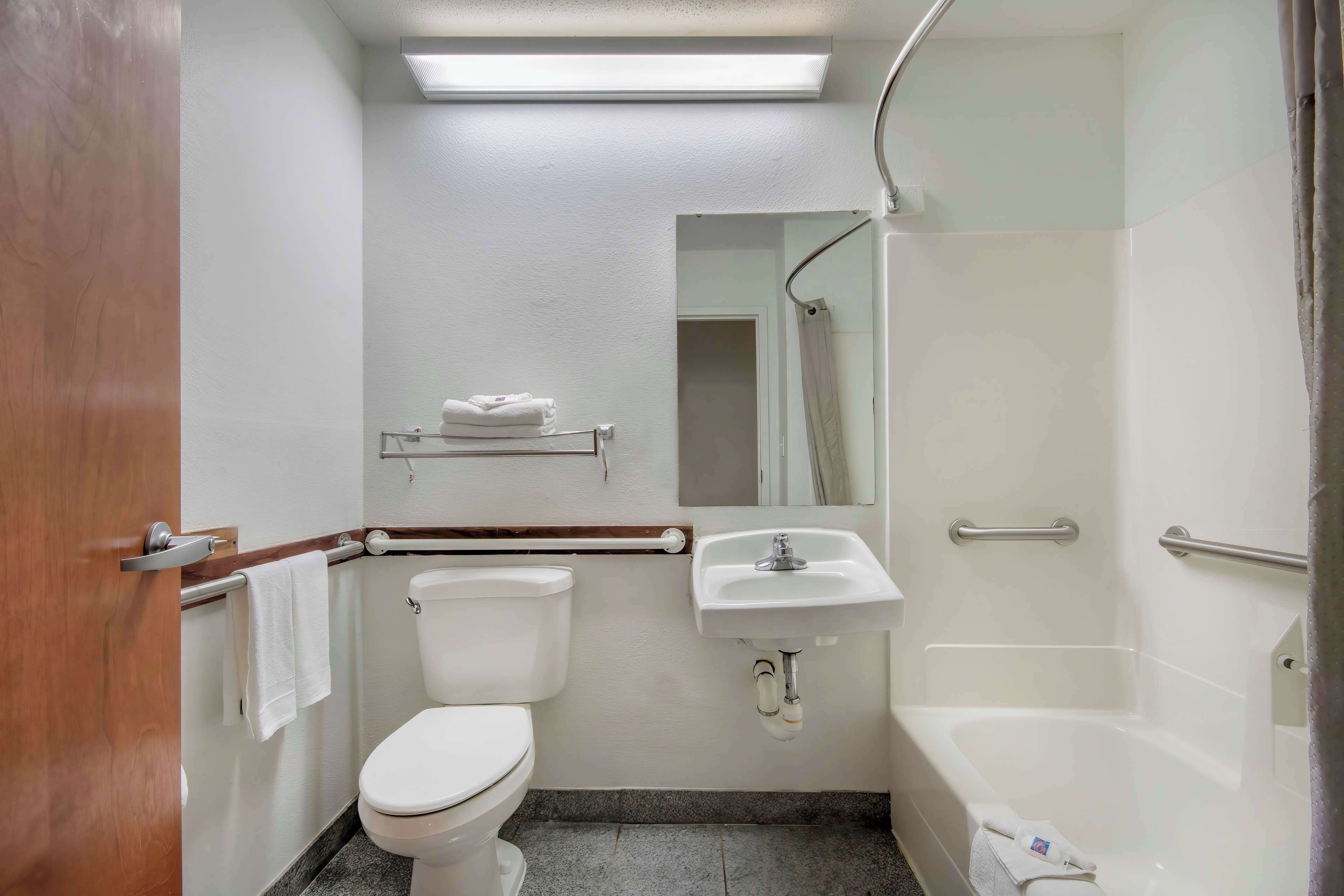 Un baño pequeño y limpio con inodoro, lavamanos y ducha.