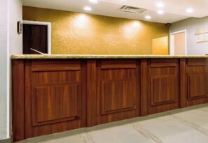 Una cocina con armarios de madera, encimera de granito e iluminación empotrada en el techo.