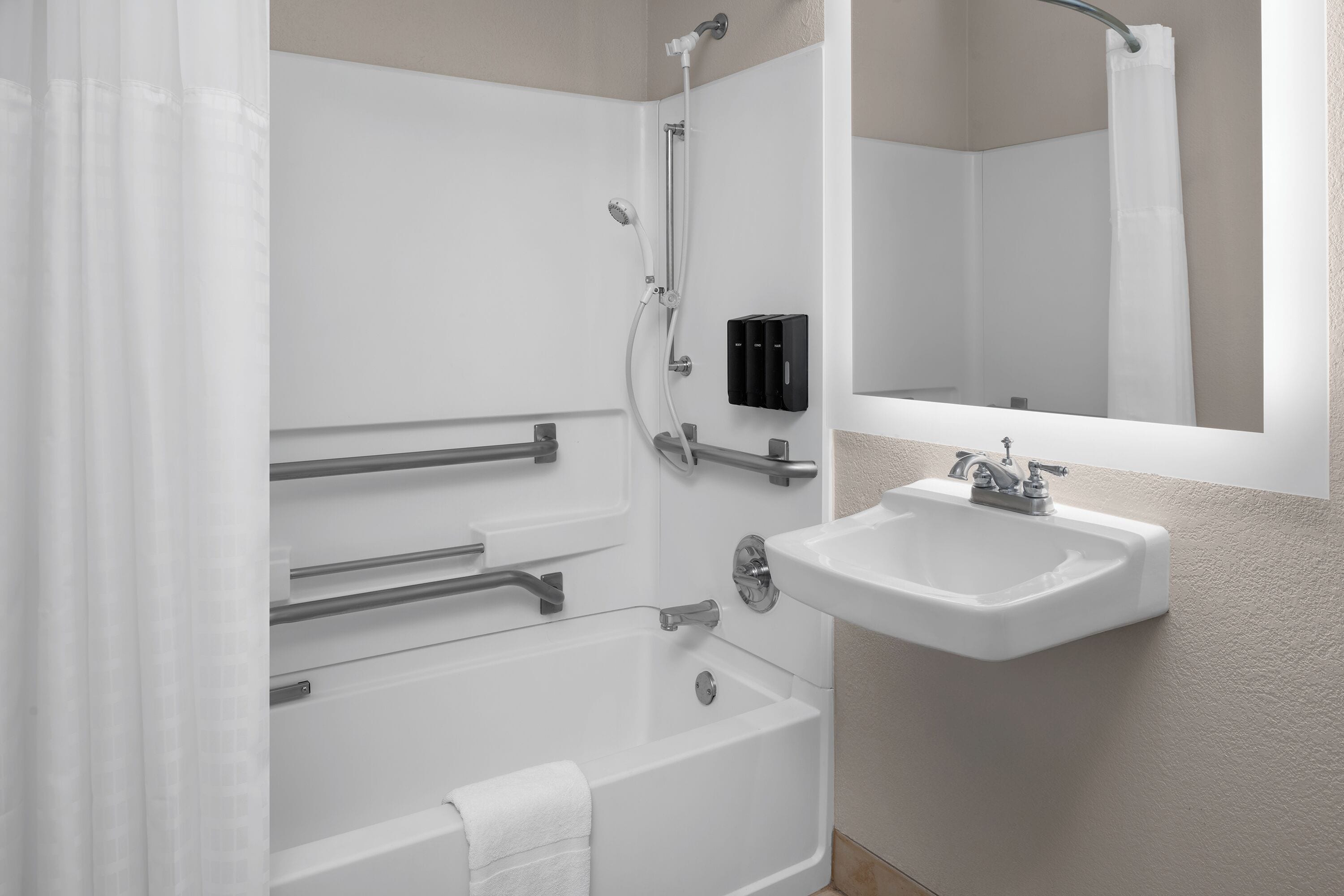 A modern bathroom with a bathtub, a sink, and a shower.