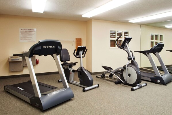 A fitness center with treadmills, stationary bikes, and a wall-mounted sign.