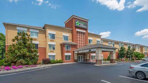 Ett Stay America-hotell med en central entré, flera fönster och en parkeringsplats.