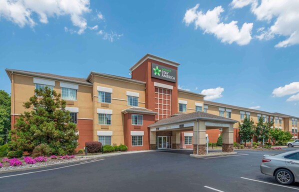 A Stay America hotel with a central entrance, multiple windows, and a parking lot.
