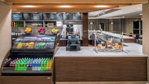 Ein Selbstbedienungs-Frühstücksbuffet mit verschiedenen Getränken und Backwaren.