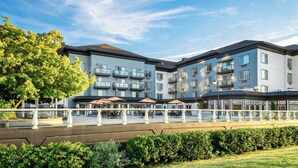 Ein mehrstöckiges Hotel mit Balkonen, Außenbereich und einer angelegten Grünfläche.