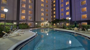 A swimming pool with lounge chairs and a hotel building in the background. - La Quinta Inn & Suites by Wyndham Orlando I Drive/Conv Ctr (Orlando)