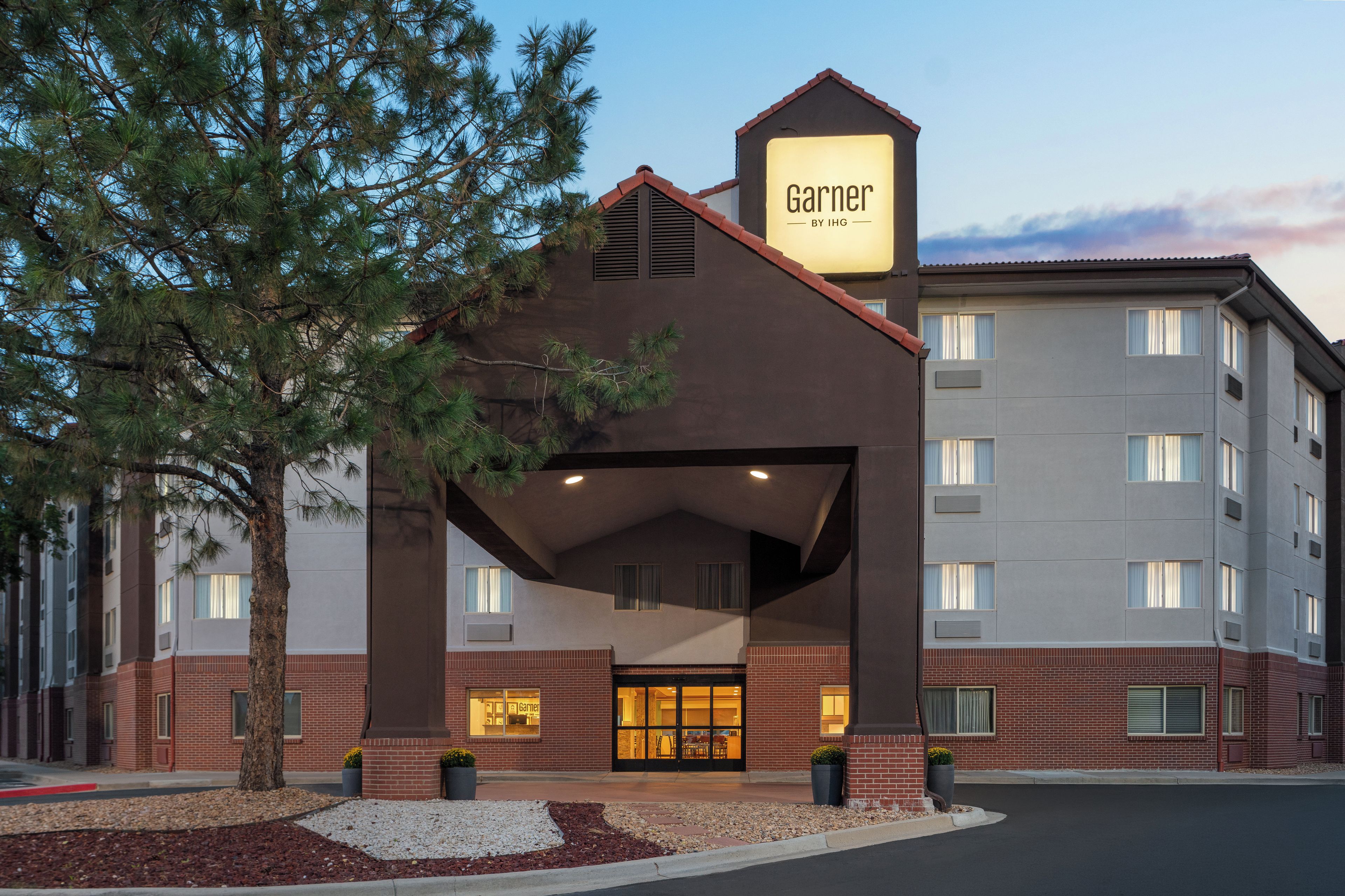 Un hotel con un llamativo letrero 'Garner', un acceso cubierto y fachada de ladrillo.