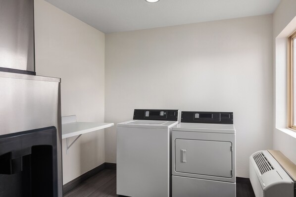 A laundry room with a dryer, a washing machine, and a vent.