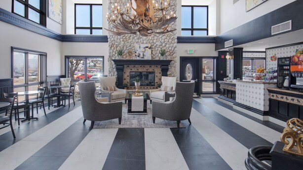 A lobby with a fireplace, seating area, and a bar. - Elkotel - The Newest Hotel in Elko (Elko)
