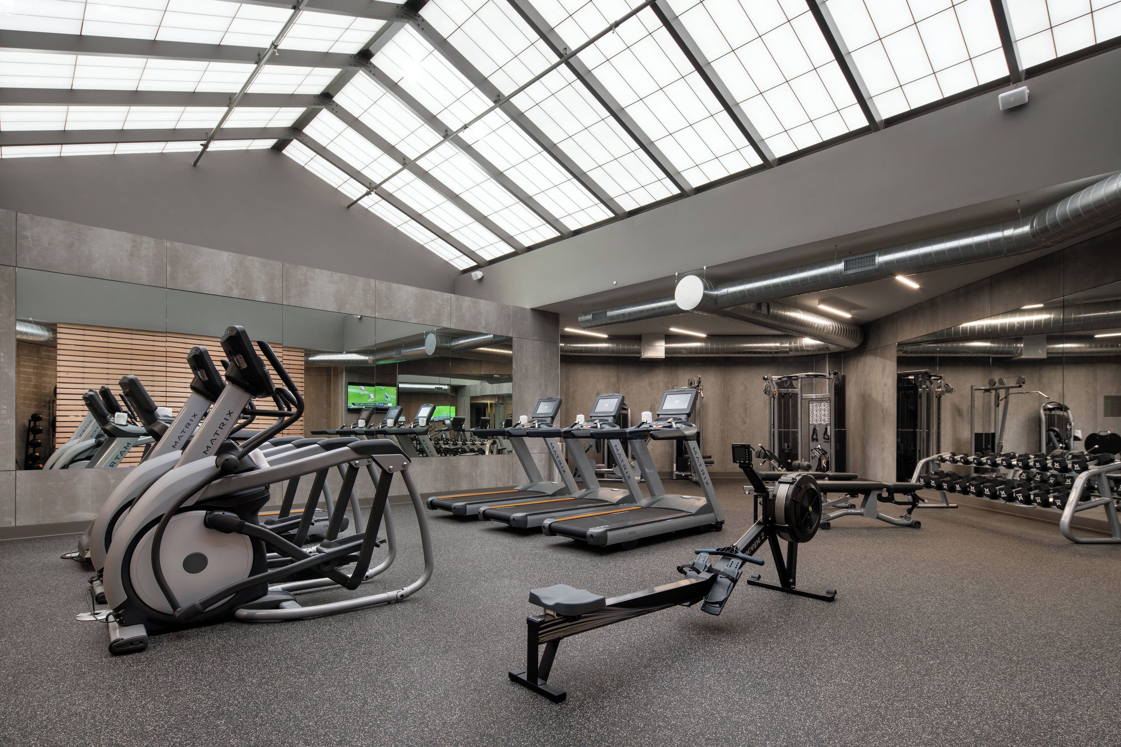 A gym with treadmills, elliptical machines, and weight equipment.
