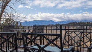 Une terrasse avec des sièges extérieurs et une vue sur la montagne.
