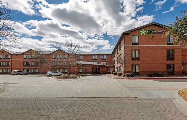 A brick building with a sign for Extended Stay America Suites. - Extended Stay America Select Suites Dallas Farmers Branch (Dallas)