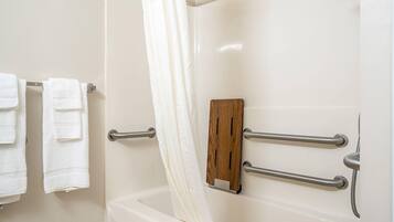 Un baño con una bañera, cortina de ducha y un perchero con dos toallas.