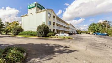 A multi-story hotel with a parking lot in front.