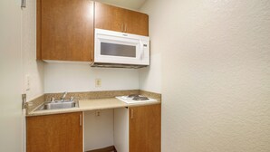 Una kitchenette compacta con microondas, pileta y cocina.