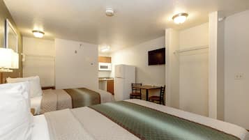 A hotel room with two beds, a desk, a chair, a television, and a microwave.