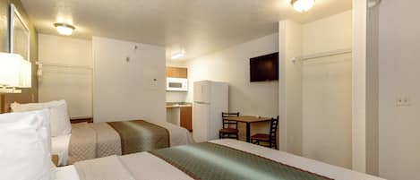 A hotel room with two beds, a desk, a chair, a television, and a microwave.