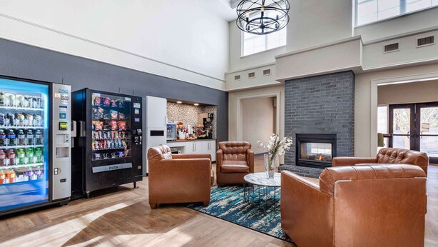 A modern living room with leather sofas, a fireplace, and vending machines. - Extended Stay America Premier Suites Charlotte Pineville Mat (Charlotte)