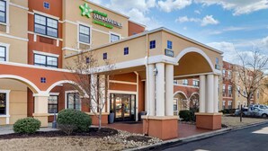 A StayAmerica hotel with a covered entrance, multiple floors, and a visible lobby sign. - Extended Stay America Premier Suites Charlotte Pineville Mat (Charlotte)