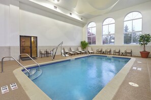 An indoor swimming pool with a clear water surface, surrounded by lounge chairs and a potted plant. - Holiday Inn Express & Suites Chicago-Libertyville by IHG (Libertyville)