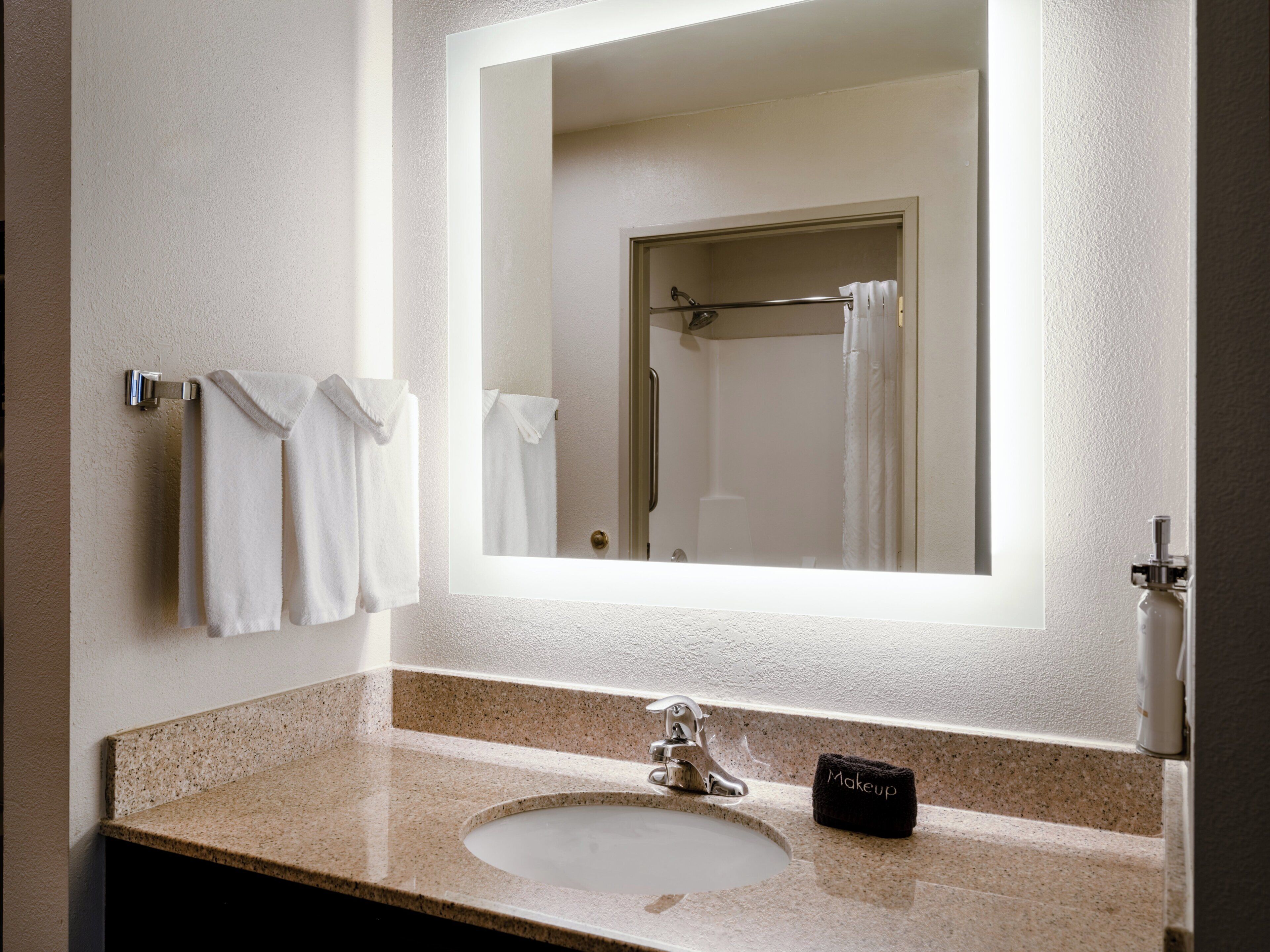 Une salle de bain équipée d’un lavabo, d’un miroir et d’un porte-serviettes.