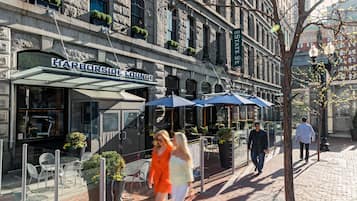 Un edificio con un letrero que dice "Harborside Lounge" y mesas al aire libre con sombrillas.