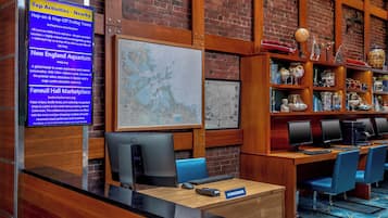 Balcão de recepção com mapa, computadores e placa de concierge.