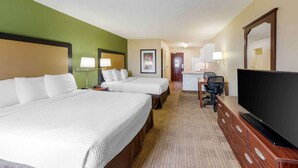 A hotel room with two beds, a desk with a chair, a television, and a bathroom in the background. - Extended Stay America Suites Orange County Huntington Beach (Huntington Beach)