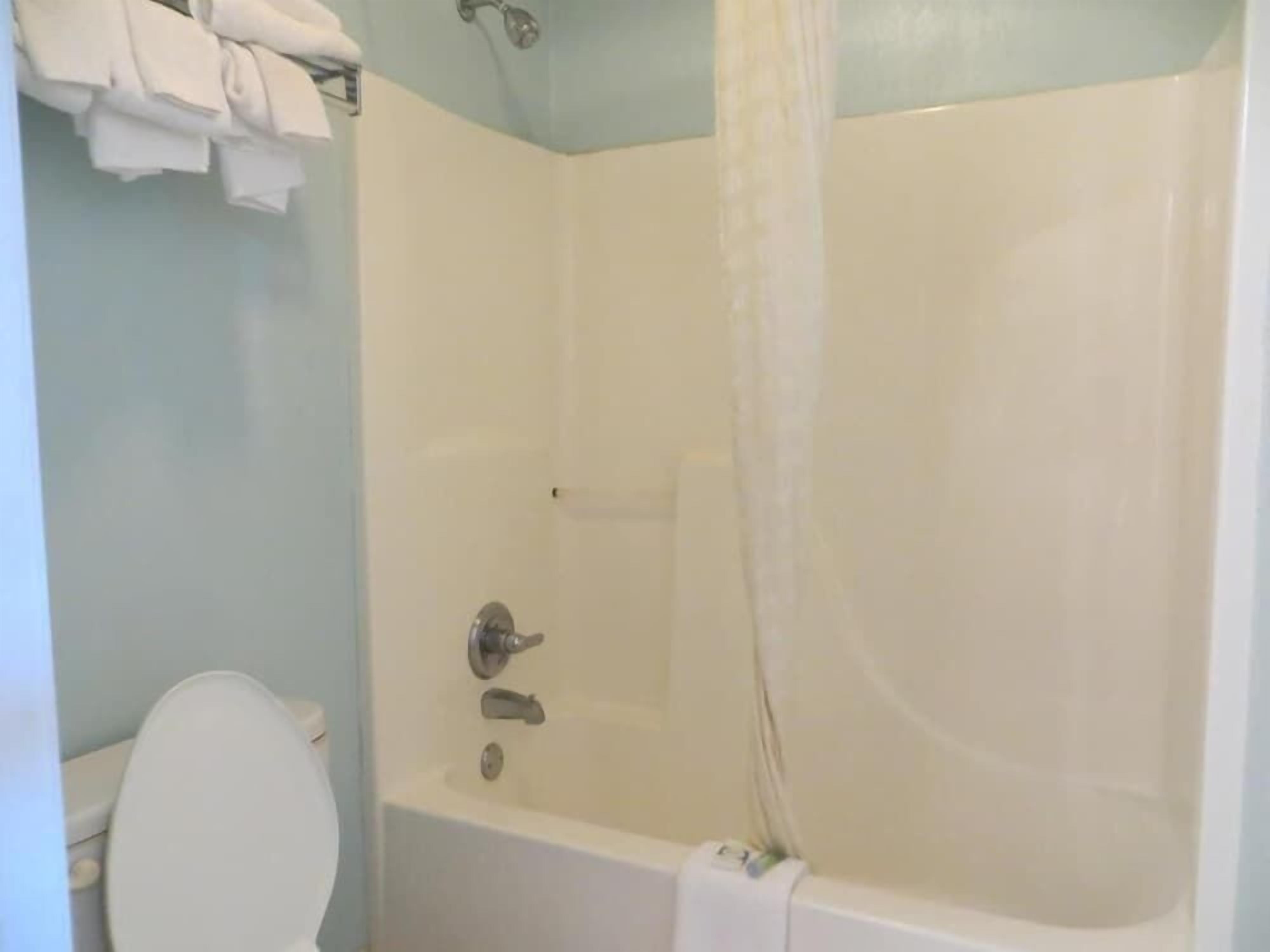 Un baño con bañera, inodoro y un perchero para toallas.