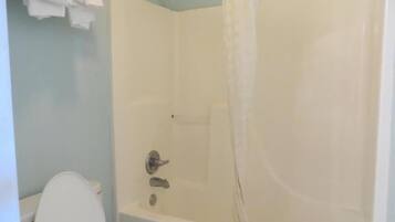 Un baño con bañera, inodoro y un perchero para toallas.